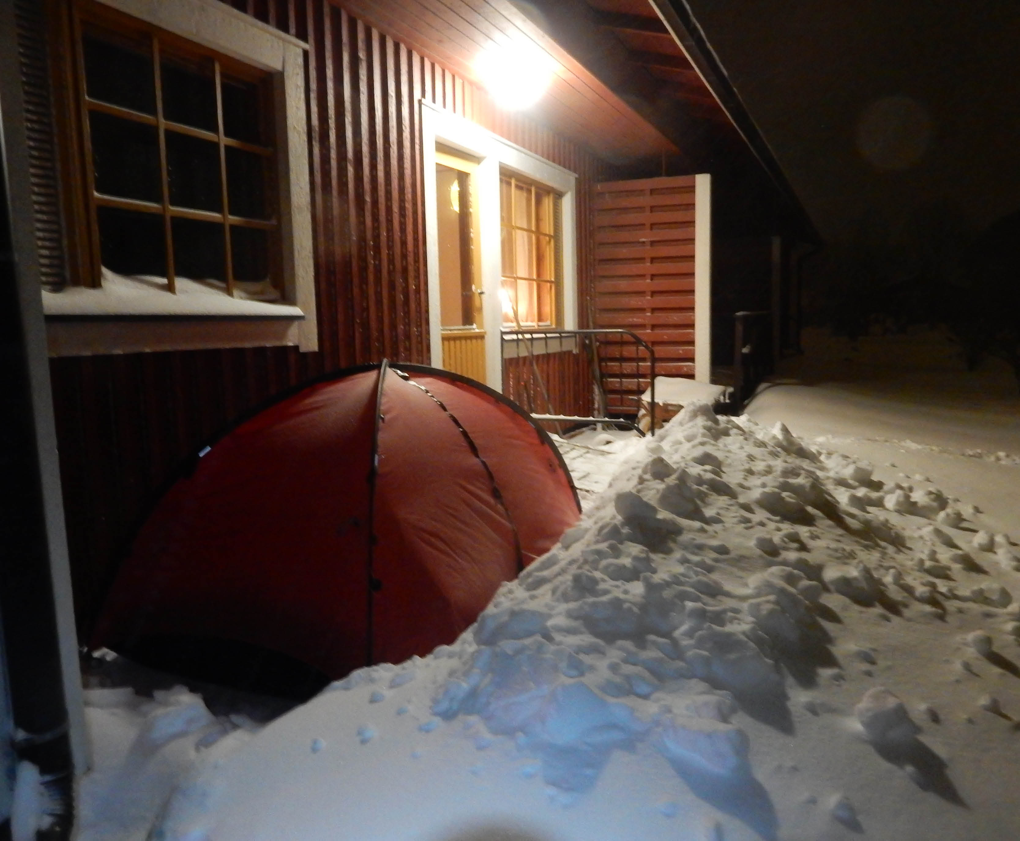 ett uppslaget tält på en altan inbäddad i snö.