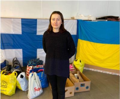 En kvinna framför finlands och ukrainas flagga